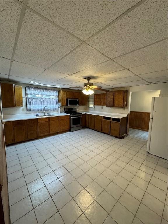 3305 Christy St, Sheraden, PA 15204 - kitchen featuring stainless steel appliances, light countertops, a sink, a drop ceiling, and brown cabinets