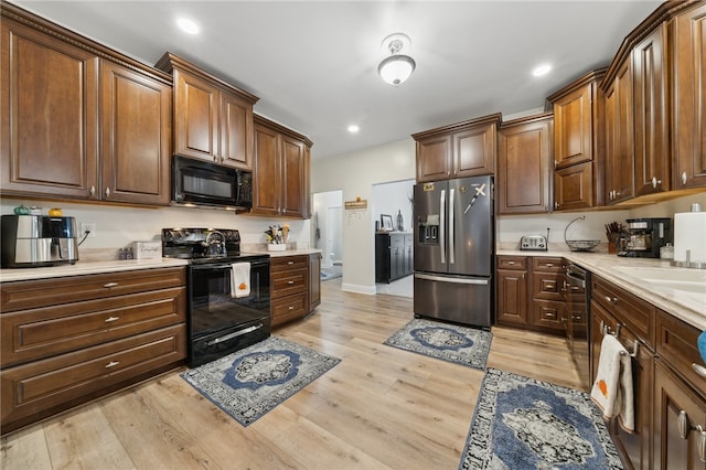 kitchen with black appliances and light wood-type flooring