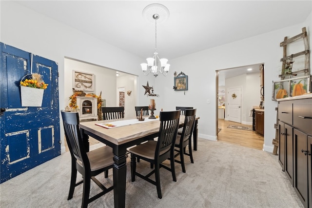 dining area featuring light carpet and an inviting chandelier