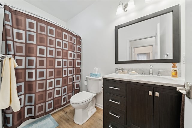 bathroom with wood-type flooring, vanity, and toilet