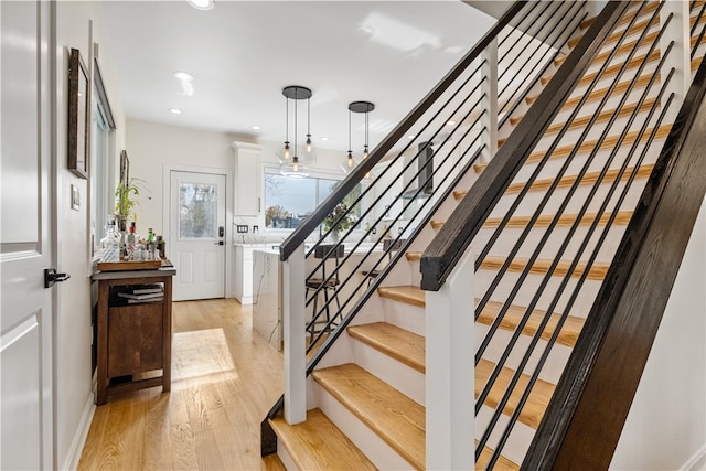 staircase with hardwood / wood-style floors