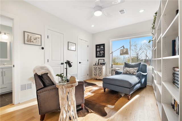 living area featuring ceiling fan and light hardwood / wood-style floors