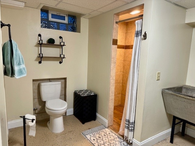 bathroom with a shower with curtain, a drop ceiling, a wall mounted AC, and toilet