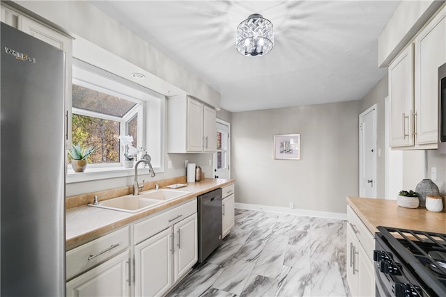 kitchen featuring white cabinets, appliances with stainless steel finishes, and sink