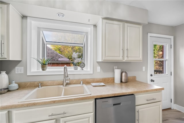 kitchen featuring dishwasher, white cabinetry, a healthy amount of sunlight, and sink