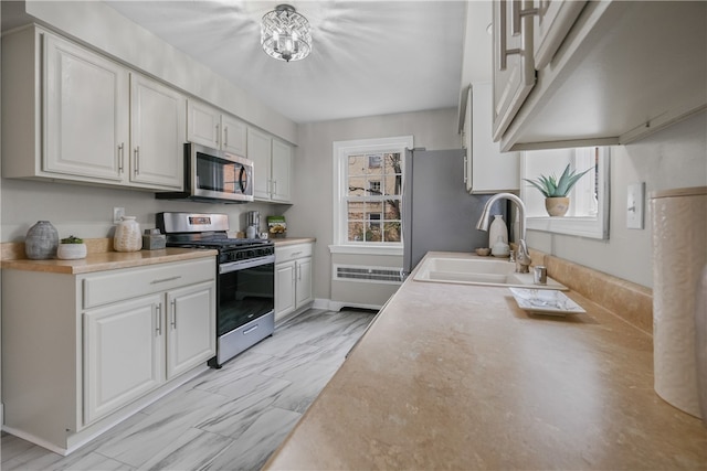 kitchen featuring stainless steel appliances, white cabinetry, and sink