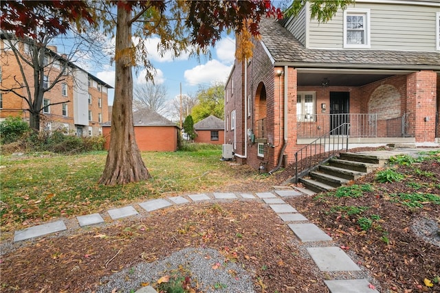 exterior space with a front yard, central air condition unit, and covered porch