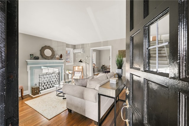 living room with wood-type flooring and a wall mounted air conditioner