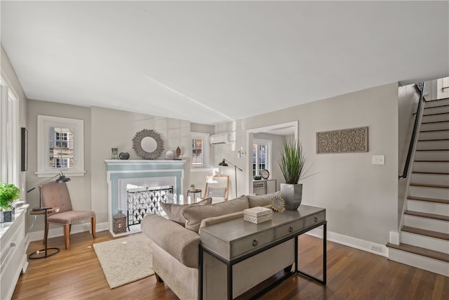 living room featuring an AC wall unit and wood-type flooring