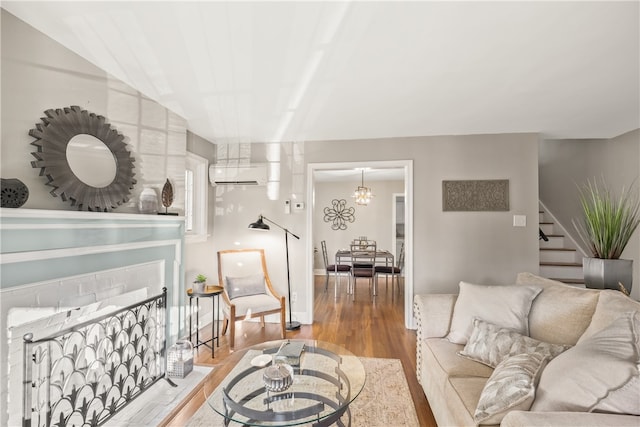 living room with hardwood / wood-style floors, an inviting chandelier, and a wall unit AC