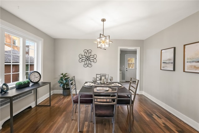 dining space featuring a chandelier, radiator heating unit, and dark wood-type flooring