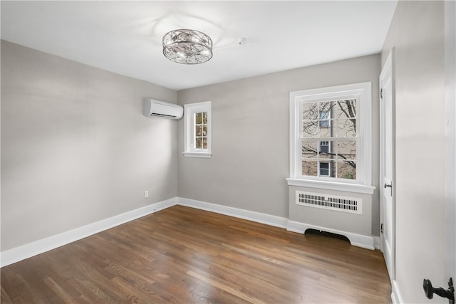 unfurnished room featuring a wall mounted air conditioner, dark hardwood / wood-style flooring, and radiator