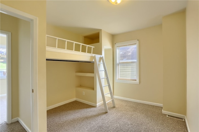 unfurnished bedroom featuring carpet flooring and a closet