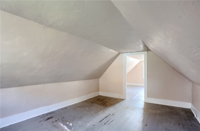 additional living space with dark hardwood / wood-style flooring and vaulted ceiling