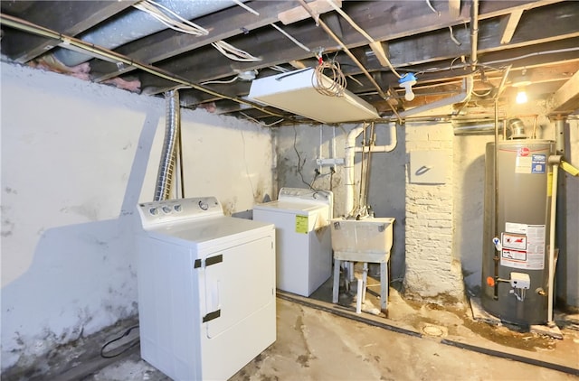 basement featuring washing machine and dryer, gas water heater, and sink