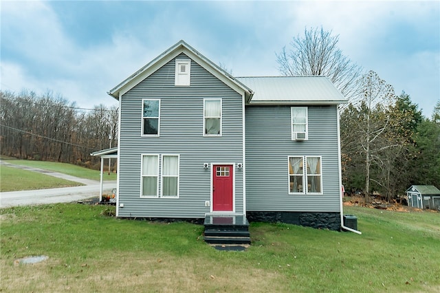 rear view of property featuring a lawn