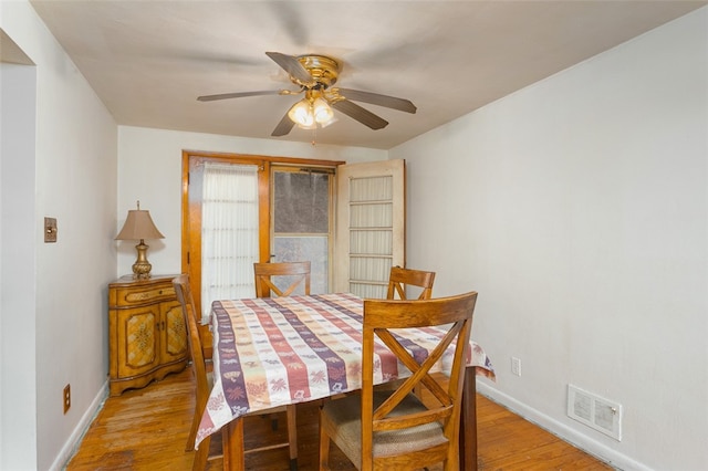 dining space with ceiling fan and light wood-type flooring