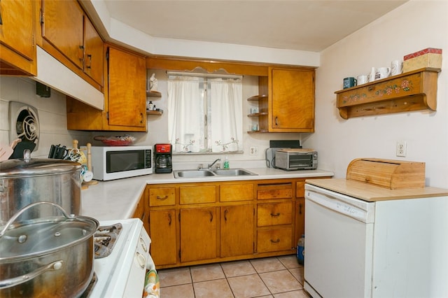 kitchen with decorative backsplash, white appliances, sink, and light tile patterned floors