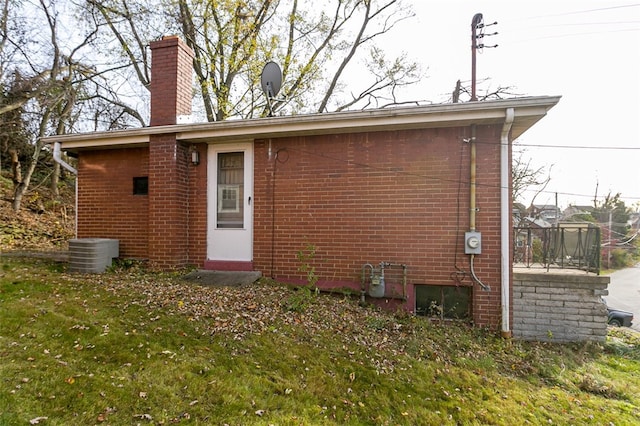 back of property featuring central air condition unit and a lawn