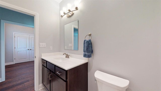 bathroom with hardwood / wood-style floors, vanity, and toilet