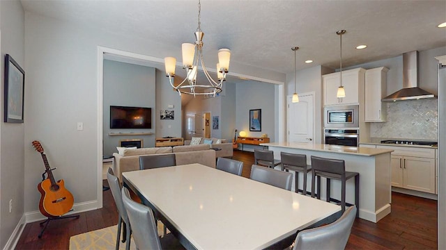 dining space featuring dark wood-type flooring and an inviting chandelier