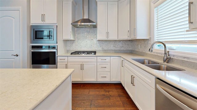 kitchen featuring dark hardwood / wood-style flooring, wall chimney exhaust hood, stainless steel appliances, sink, and white cabinets