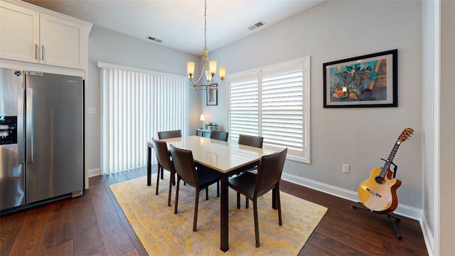 dining space featuring dark hardwood / wood-style flooring and an inviting chandelier