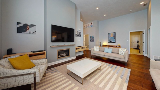 living room featuring hardwood / wood-style flooring and high vaulted ceiling