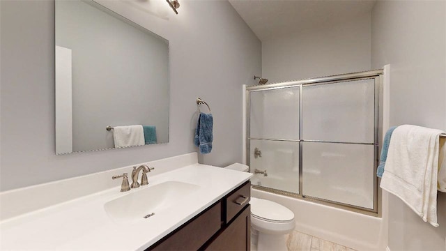 full bathroom featuring vanity, enclosed tub / shower combo, and toilet