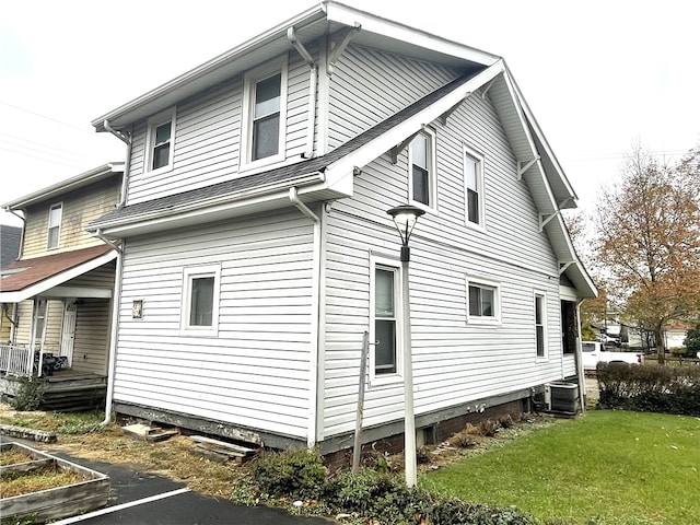 back of house featuring a lawn and central AC unit