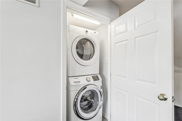 washroom featuring stacked washer / dryer