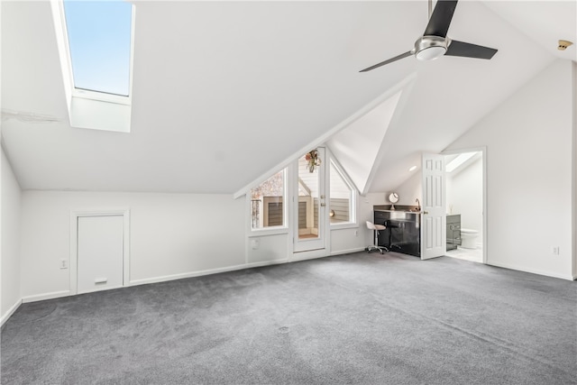 bonus room with ceiling fan, vaulted ceiling with skylight, and carpet