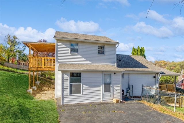 rear view of property with a deck and a yard