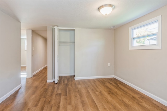 unfurnished bedroom with hardwood / wood-style flooring and a closet