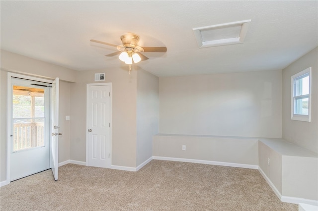 unfurnished room featuring plenty of natural light, ceiling fan, and light colored carpet