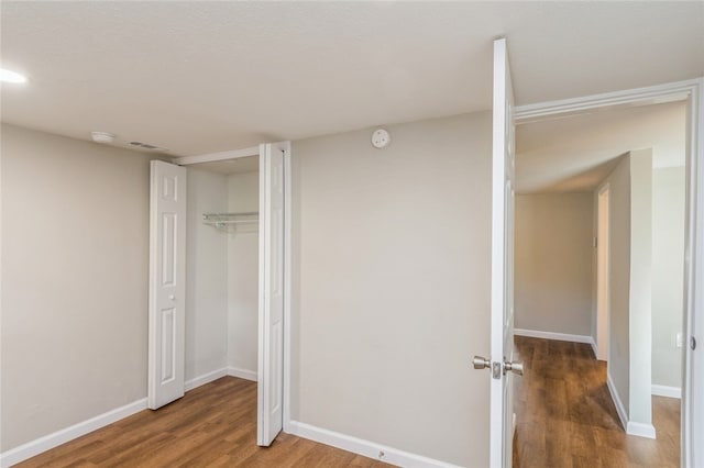 unfurnished bedroom featuring hardwood / wood-style floors and a closet