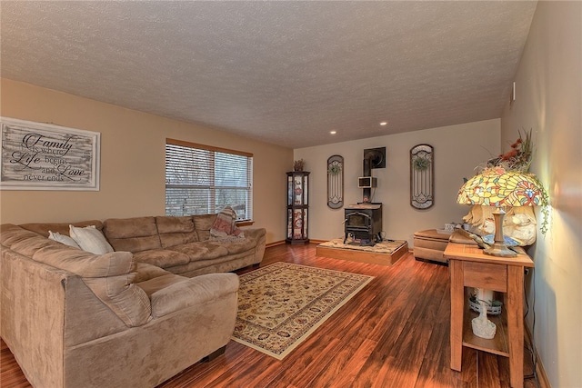 living room featuring hardwood / wood-style floors, a textured ceiling, and a wood stove