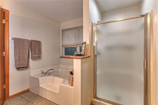 bathroom featuring tile patterned floors, plus walk in shower, and a textured ceiling