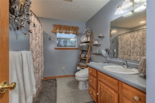 bathroom featuring tile patterned floors, vanity, toilet, and a textured ceiling