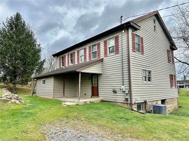 view of front of home featuring a front yard, central AC unit, and a patio area