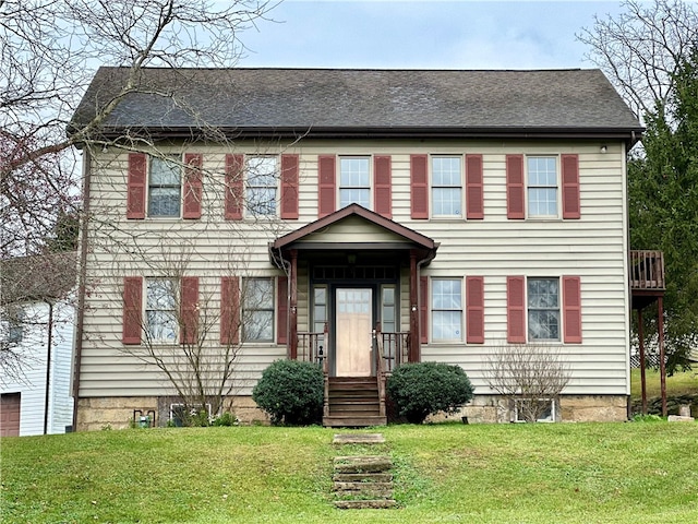 colonial inspired home with a front lawn