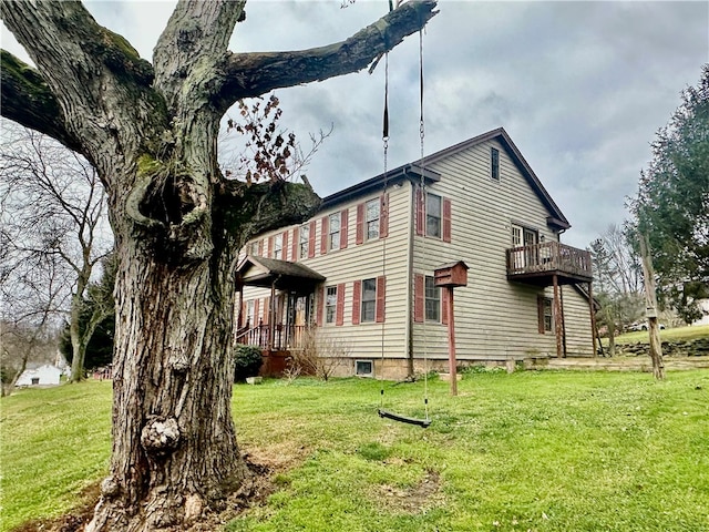 view of side of property with a yard and a balcony