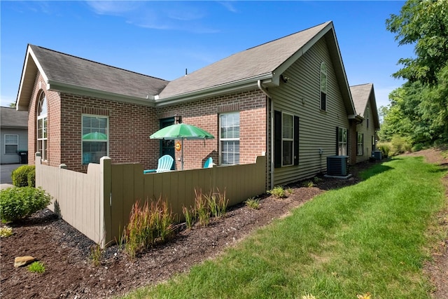 view of property exterior featuring a lawn and central air condition unit