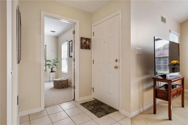 foyer entrance featuring light tile patterned flooring and a textured ceiling