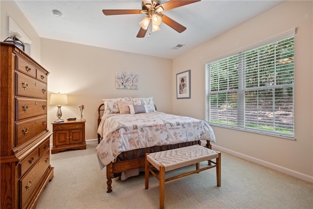 bedroom with ceiling fan and light carpet