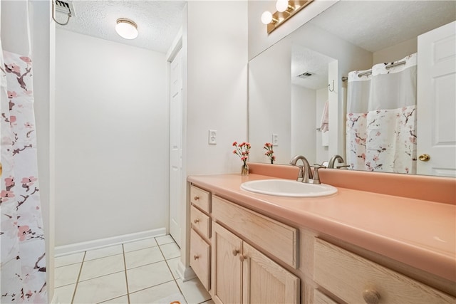 bathroom featuring tile patterned flooring, vanity, and a textured ceiling