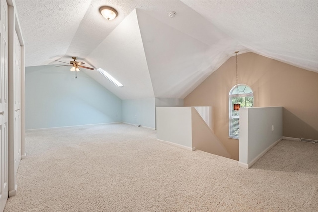 additional living space featuring a textured ceiling, ceiling fan, carpet, and lofted ceiling