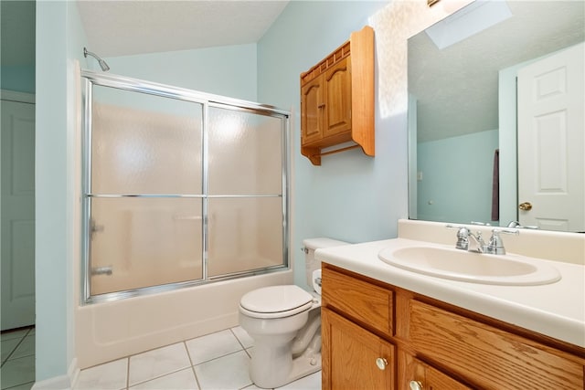 full bathroom featuring tile patterned floors, toilet, combined bath / shower with glass door, and vanity