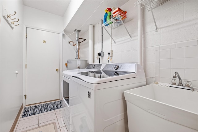 laundry area featuring sink, light tile patterned floors, and independent washer and dryer