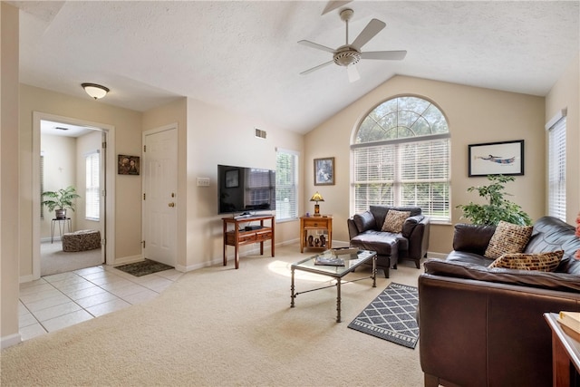 tiled living room with a textured ceiling, ceiling fan, and vaulted ceiling